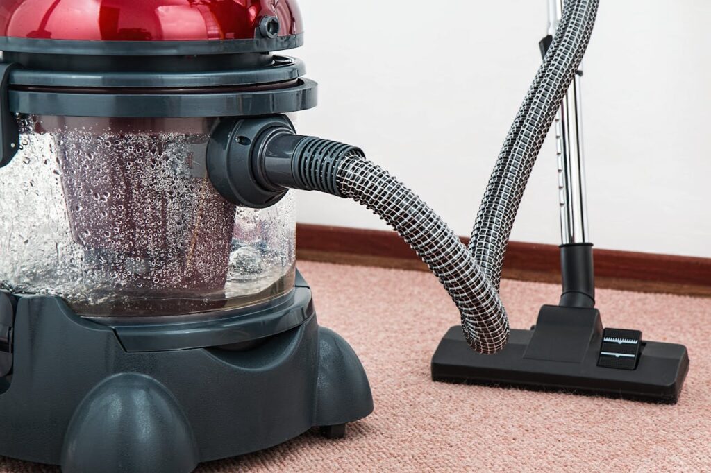 vacuum-cleaner-carpet-cleaner-housework-housekeeping-38325 Close-up of a modern vacuum cleaner with water filtration on carpet floor indoors.